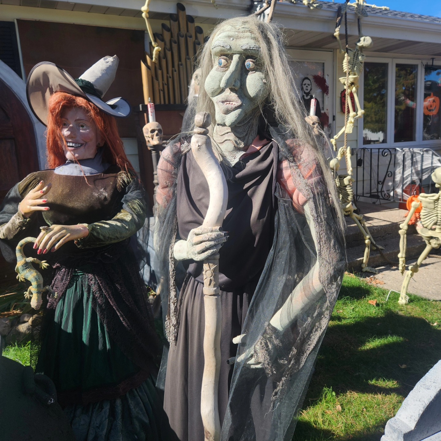 A long-haired green-faced horror figure and a red-haired witch in the daytime display — Hills of Unrest, October 2024.