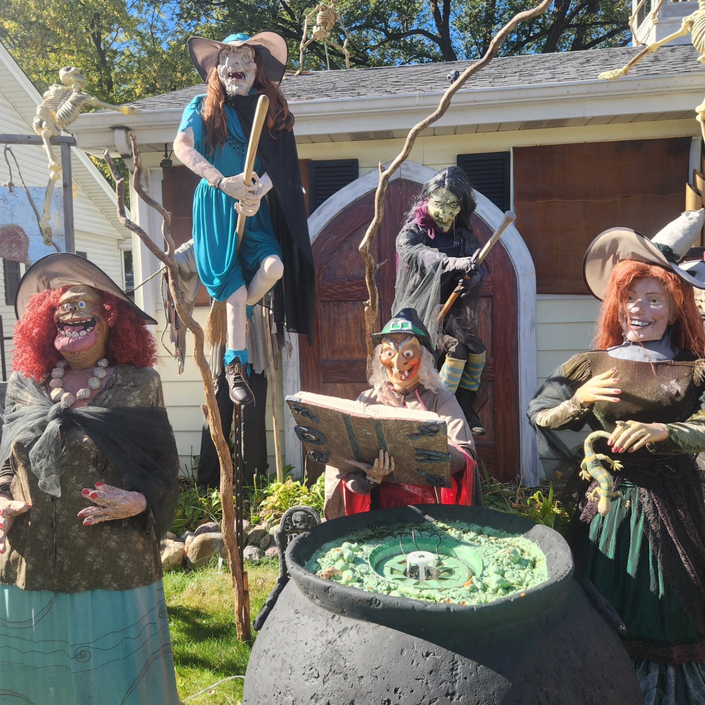 Witches gathered around a cauldron with a broom and twisted branches in the yard — Hills of Unrest, October 2024.