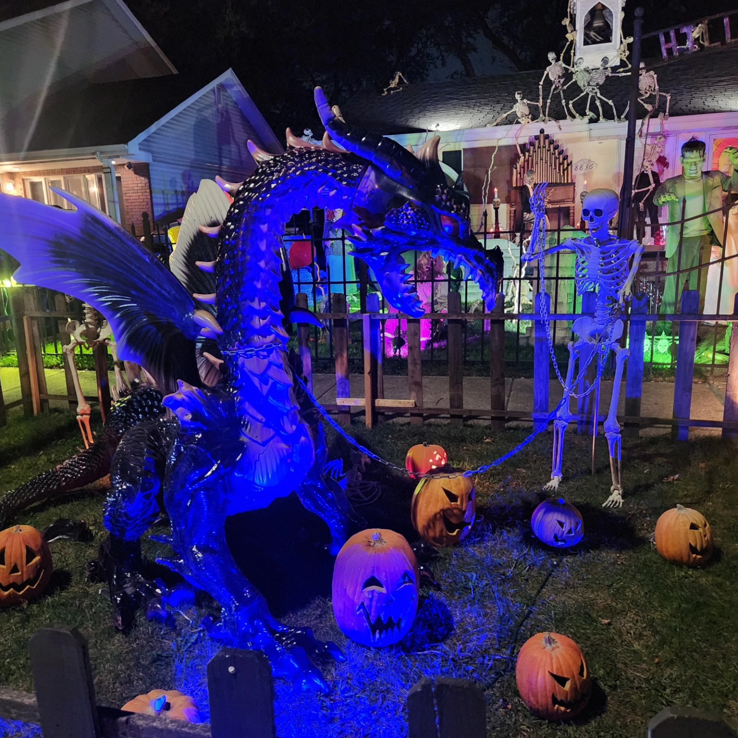 A winged dragon, skeletons and pumpkins illuminated in blue at Hills of Unrest — Hills of Unrest, October 2024.